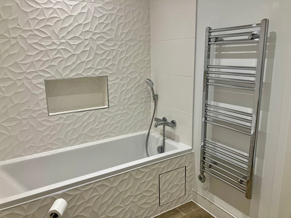 A bathroom with a bathtub and shower fittings at 12 Brewhouse Place Weymouth