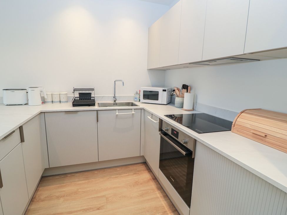 A kitchen with appliances and cabinets at Brewery View in Weymouth