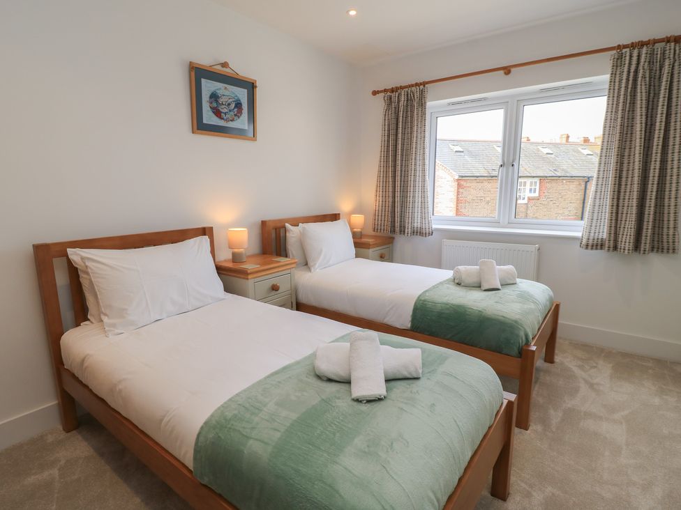 A bedroom with two single beds and a window at Brewery View in Weymouth