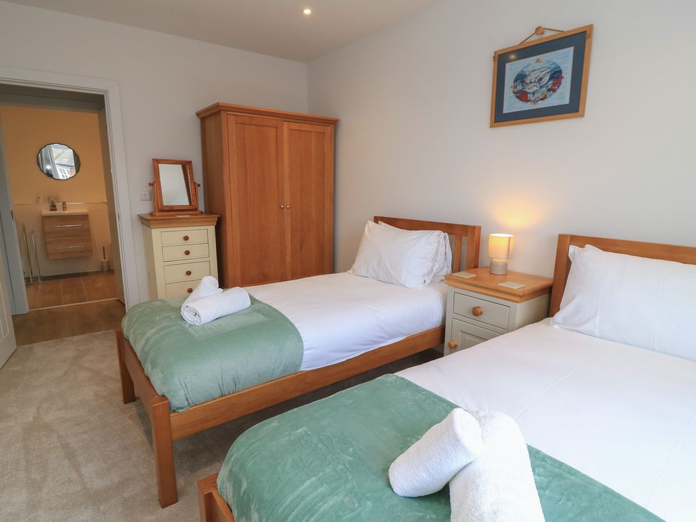 A bedroom with two beds and a nightstand at Brewery View in Weymouth