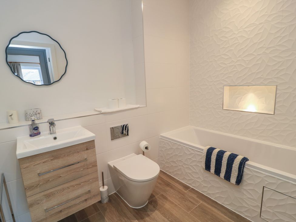 A bathroom with a bathtub, toilet, and sink at Brewery View in Weymouth