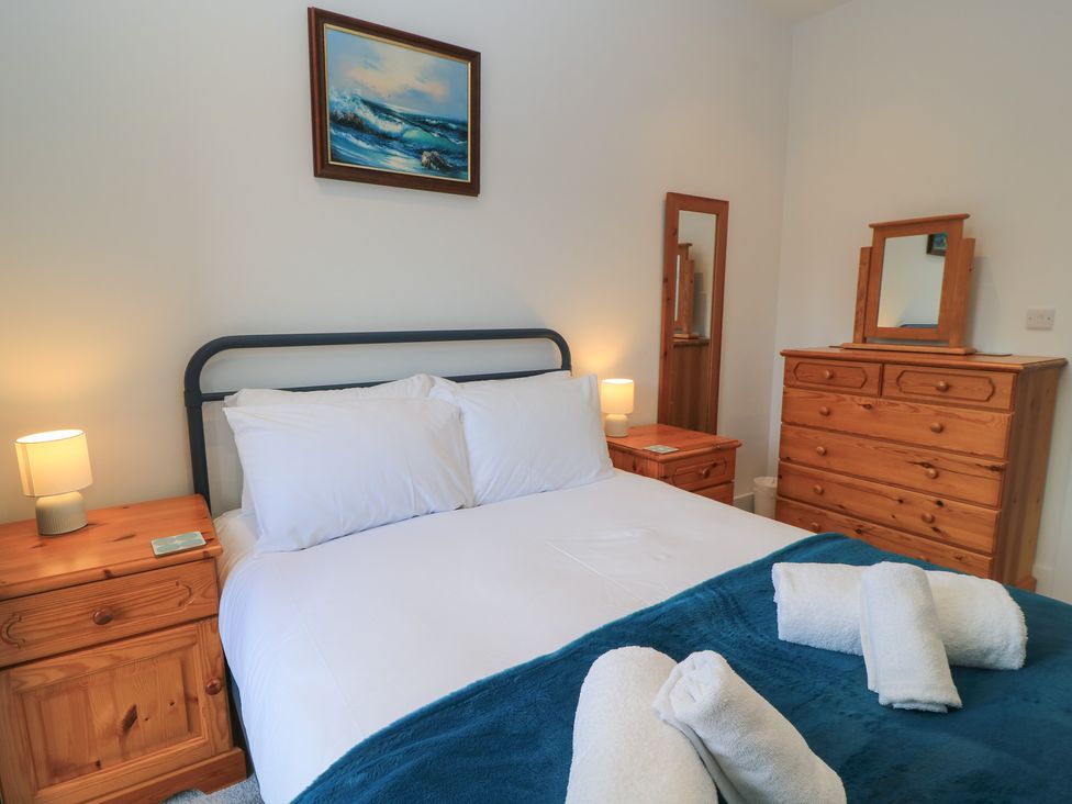 A bedroom with a bed and wooden furniture at Brewery View in Weymouth