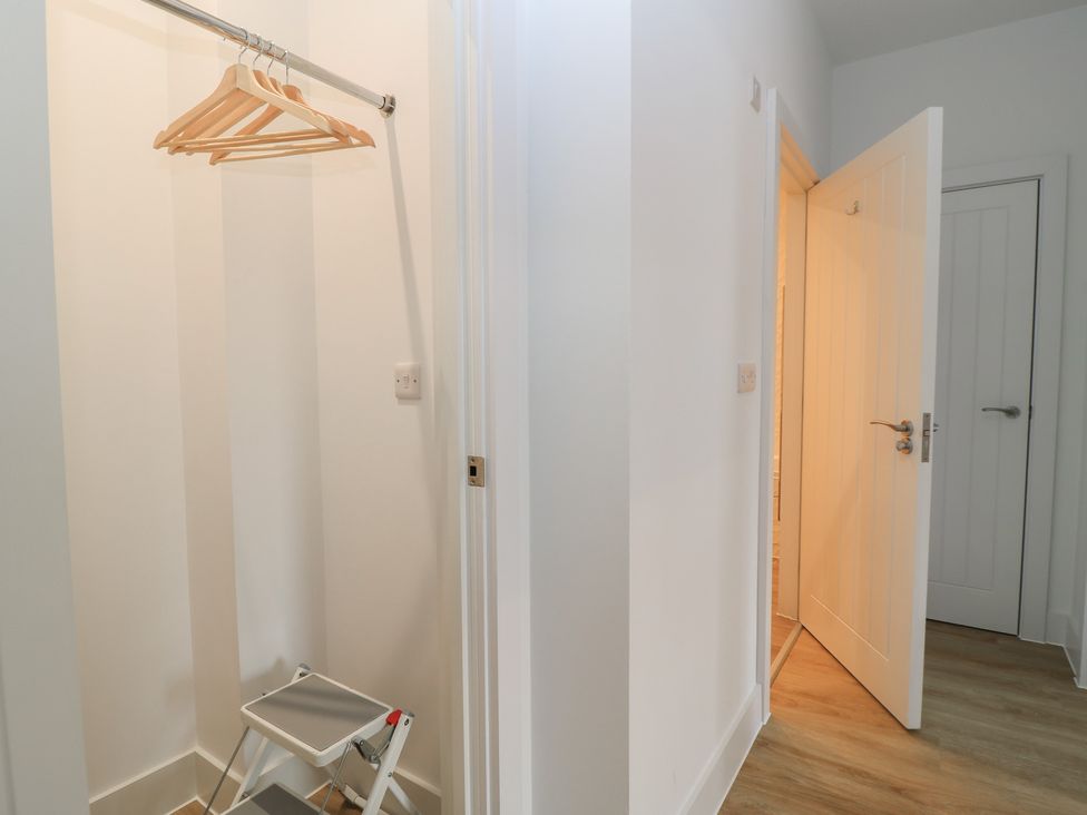 A hallway with a clothing rack and a stool at Brewery View in Weymouth