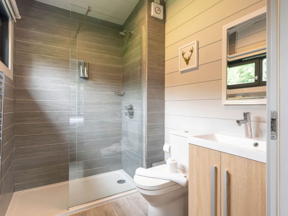 A bathroom with a shower, toilet, sink and mirror at Askrigg (Pet) Aysgarth