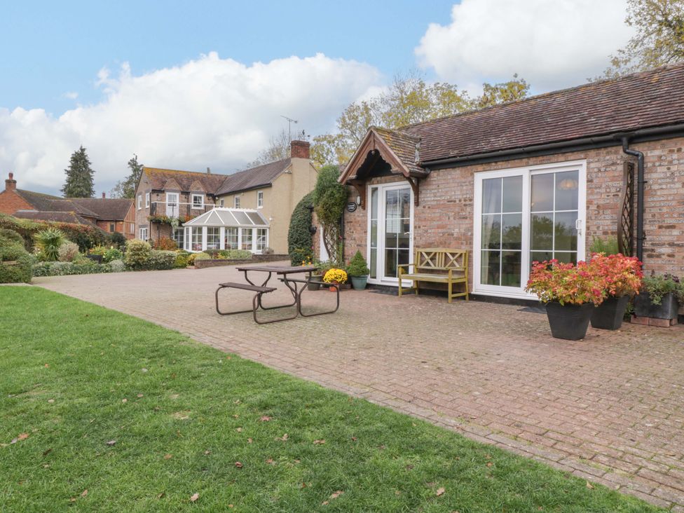 A garden with a dining table and chairs at Dovecote Cottage in Corse near Gloucester