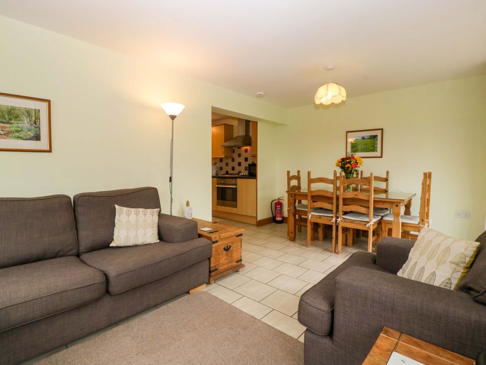 A living room with a sofa and dining area at Dovecote Cottage in Corse near Gloucester