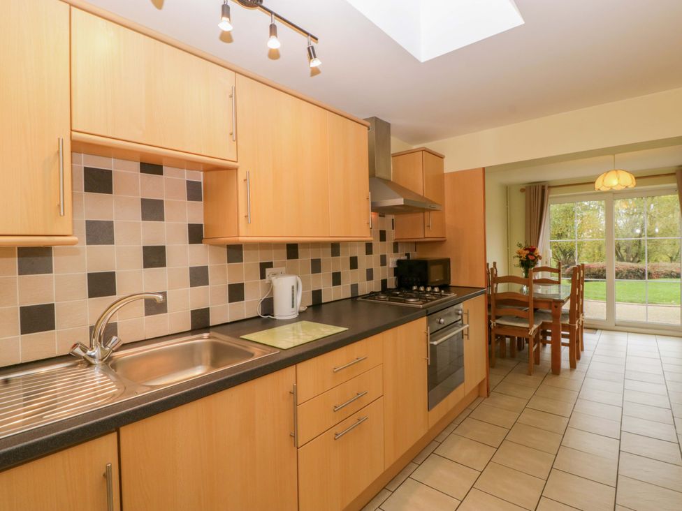 A kitchen with cabinets and dining area at Dovecote Cottage Corse near Gloucester