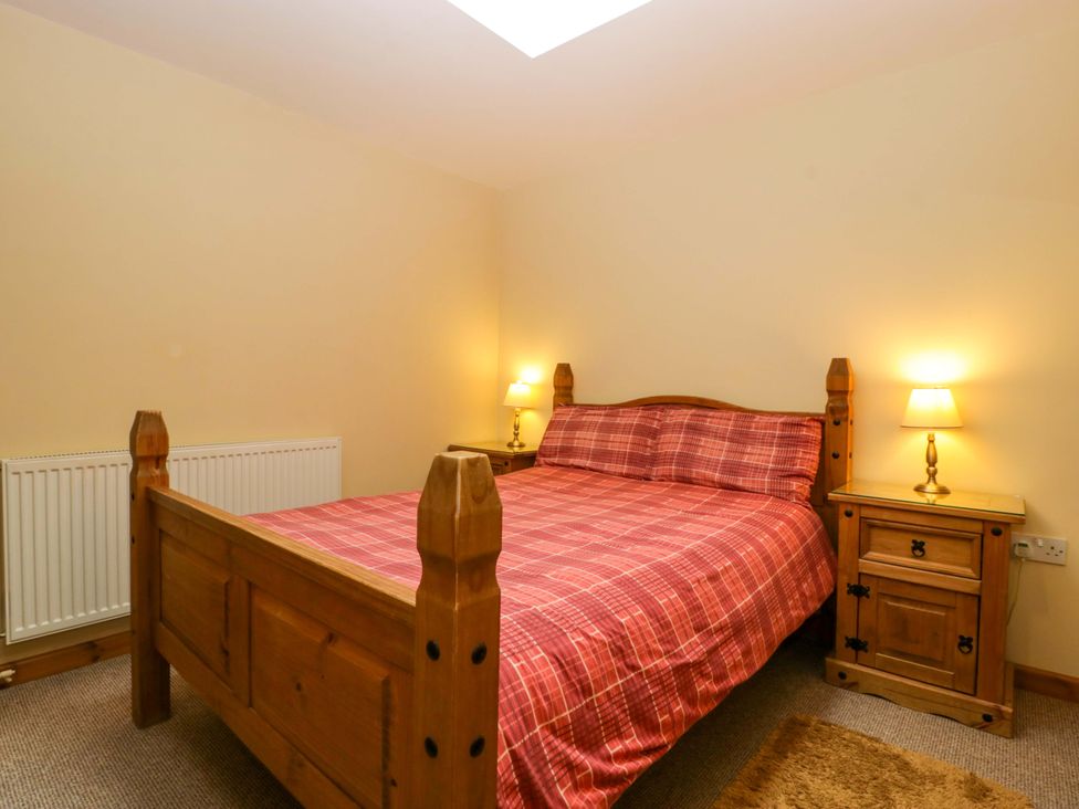 A bedroom with a bed and nightstand at Dovecote Cottage Corse near Gloucester