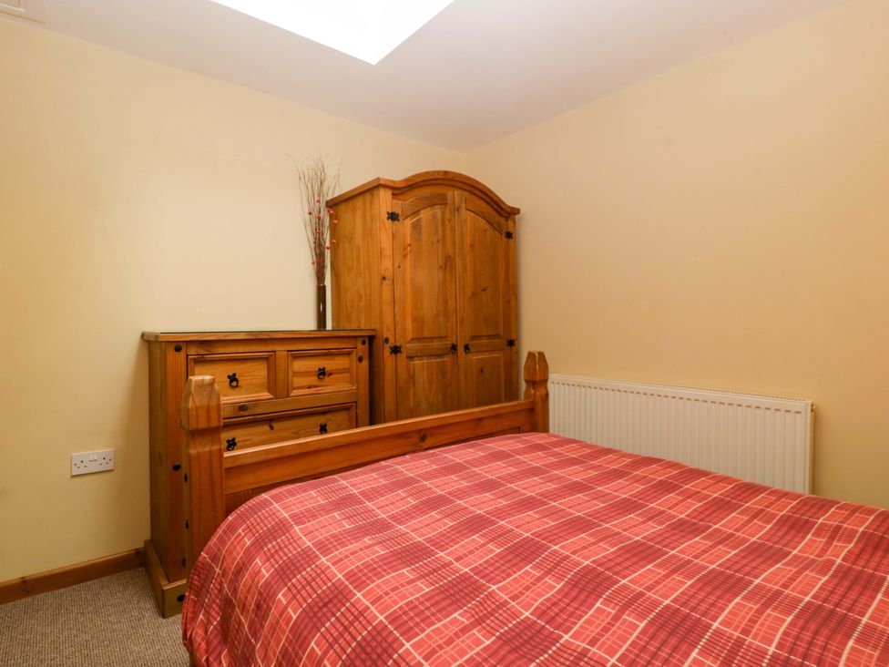 A bedroom with wooden furniture and a skylight at Dovecote Cottage Corse near Gloucester