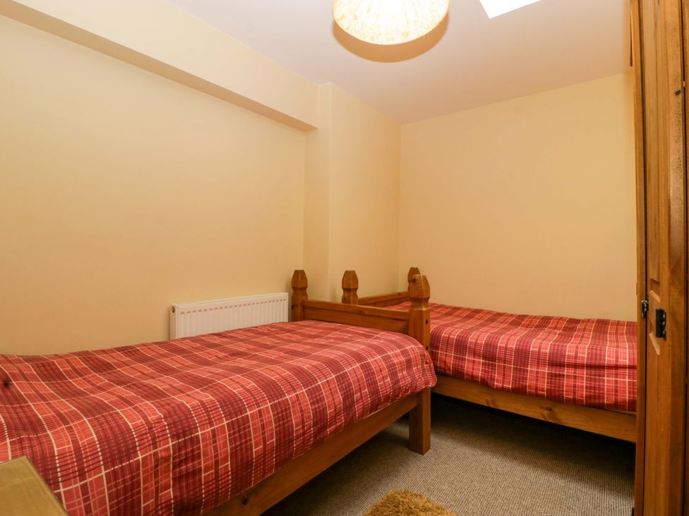 A bedroom with twin beds and a radiator at Dovecote Cottage in Corse near Gloucester