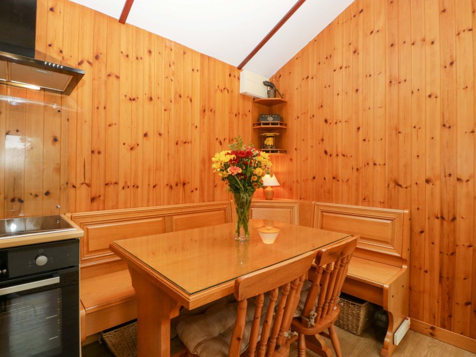 A kitchen with a table and benches at The Log Cabin in Corse near Gloucester