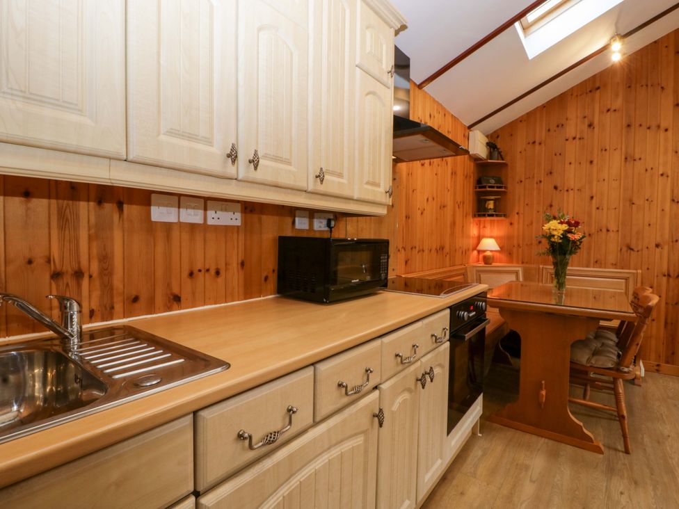 A kitchen with cabinets and appliances at The Log Cabin in Corse near Gloucester