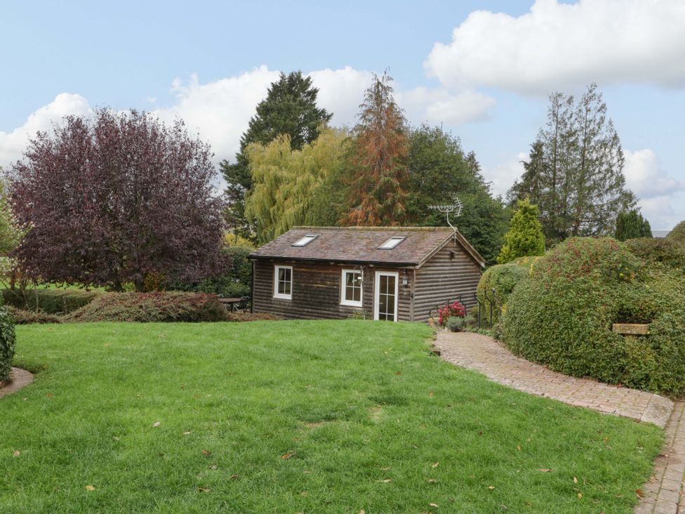 A garden with a wooden shed and pathway at The Log Cabin in Corse near Gloucester