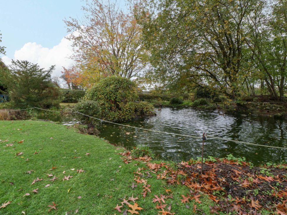 An outdoor area with a pond and trees at The Log Cabin in Corse near Gloucester