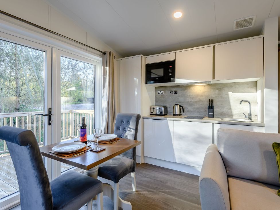 A kitchen with a dining table and chairs at Somersby Spa in Louth