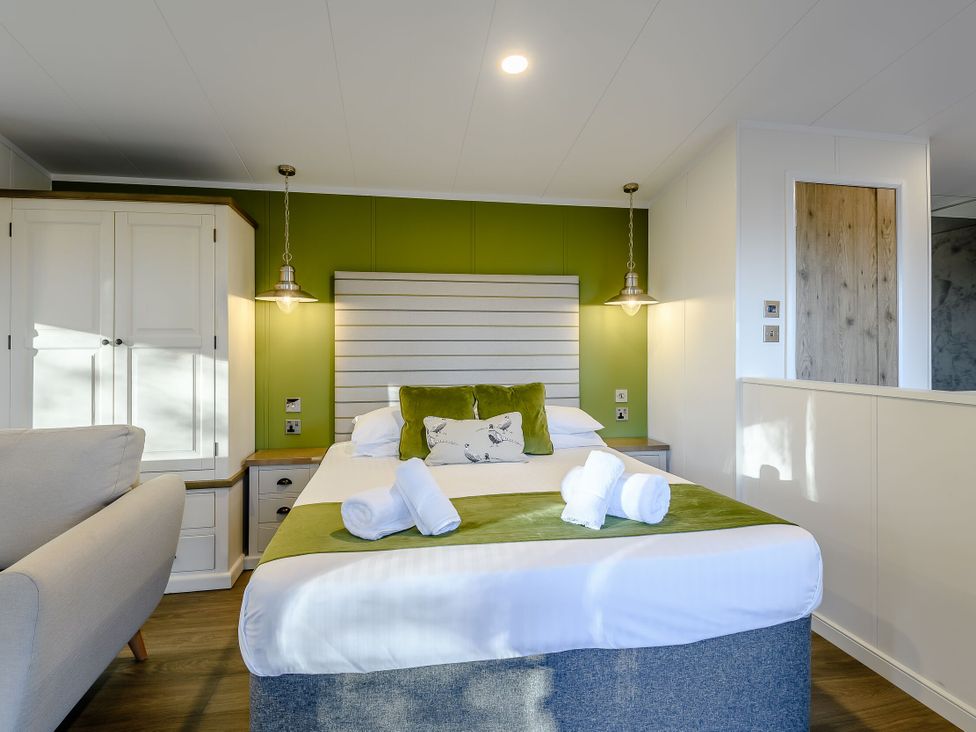A bedroom with a bed and cabinet at Somersby Spa in Louth