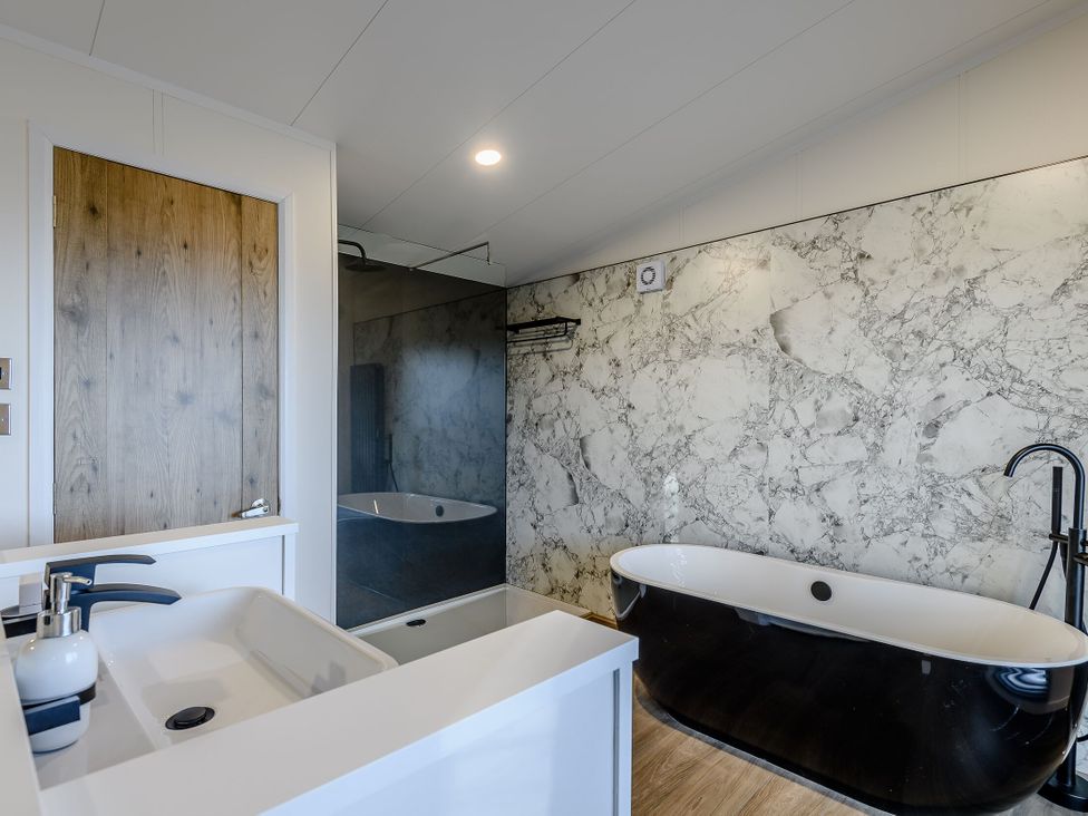 A bathroom with a bathtub and sink at Somersby Spa, Louth