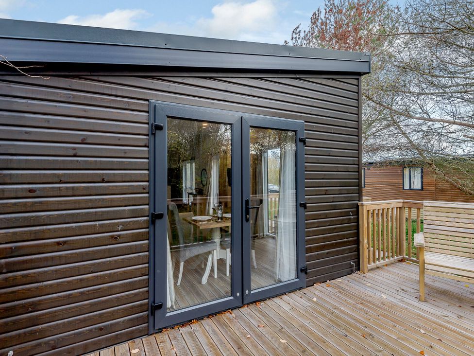 A deck with double doors and outdoor seating at Somersby Spa in Louth
