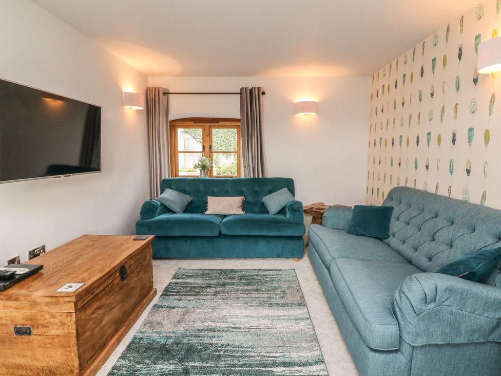 A living room with a television and two sofas at Higher Forda in Holsworthy