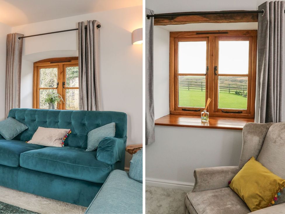 A living room with a sofa and window at Higher Forda in Holsworthy