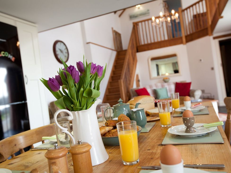 A dining table set for breakfast with eggs and juice at Higher Forda in Holsworthy