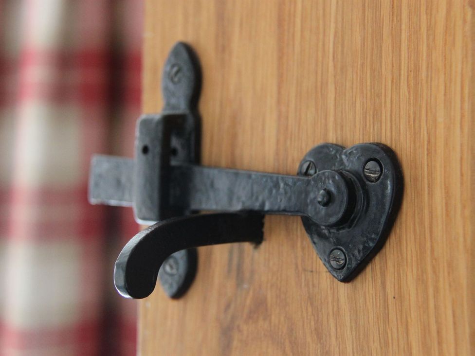 A metal door latch on a wooden door at Higher Forda Holsworthy