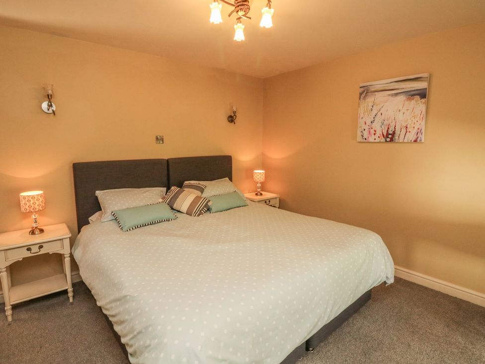A bedroom with a bed and nightstands at Higher Forda in Holsworthy