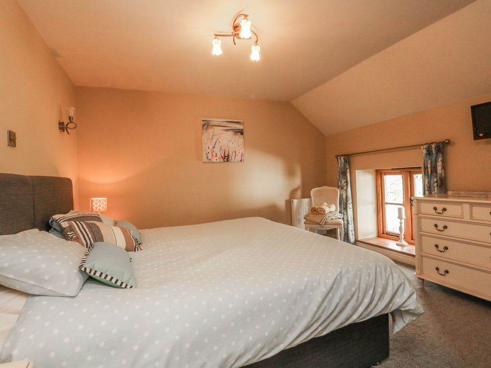 A bedroom featuring a bed and a window at Higher Forda in Holsworthy