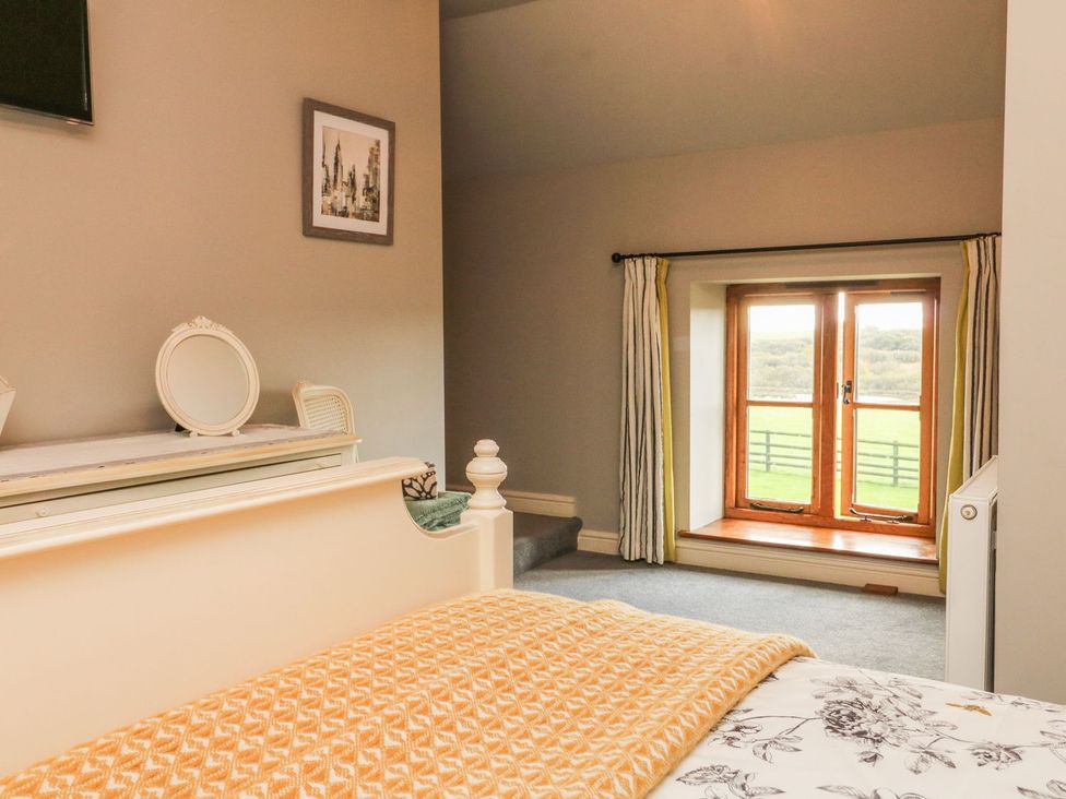 A bedroom with a bed and window at Higher Forda in Holsworthy