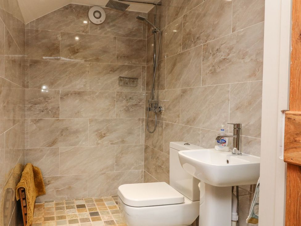 A bathroom with a shower, toilet, and sink at Higher Forda in Holsworthy