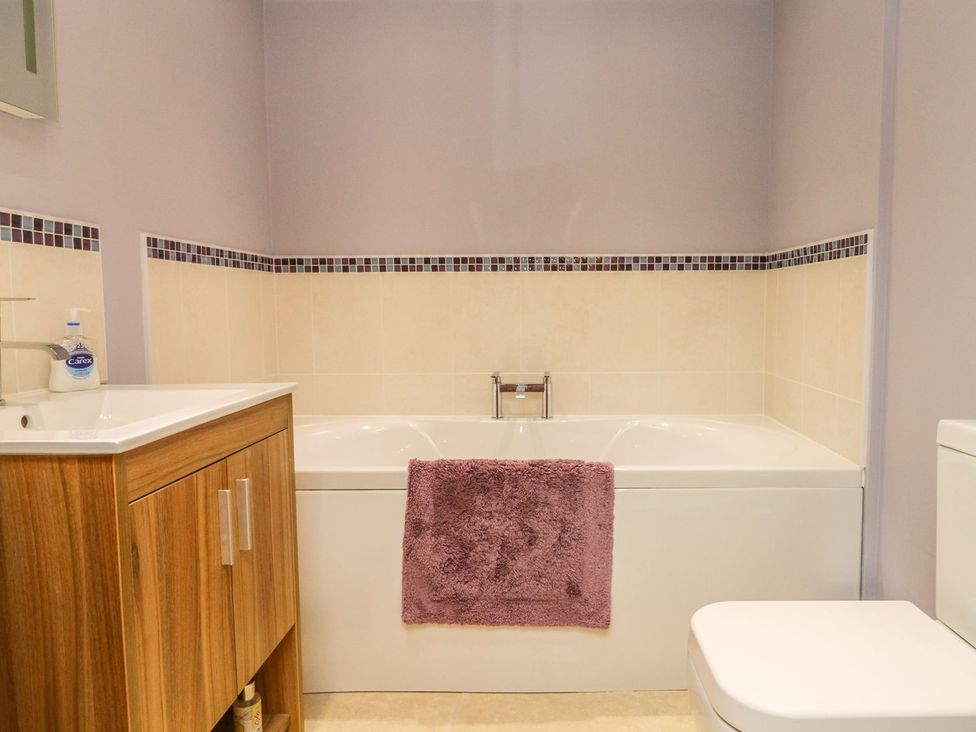 A bathroom with a bathtub, sink, and toilet at Higher Forda in Holsworthy