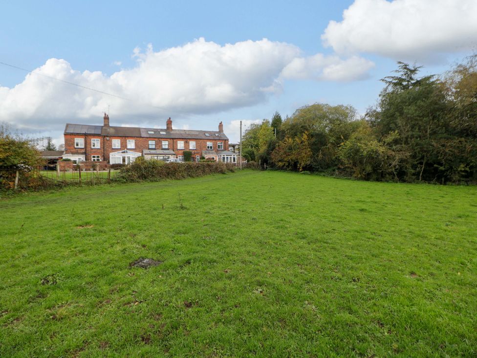 A grassy area with a house and trees at Shunter’s Nook in Stafford