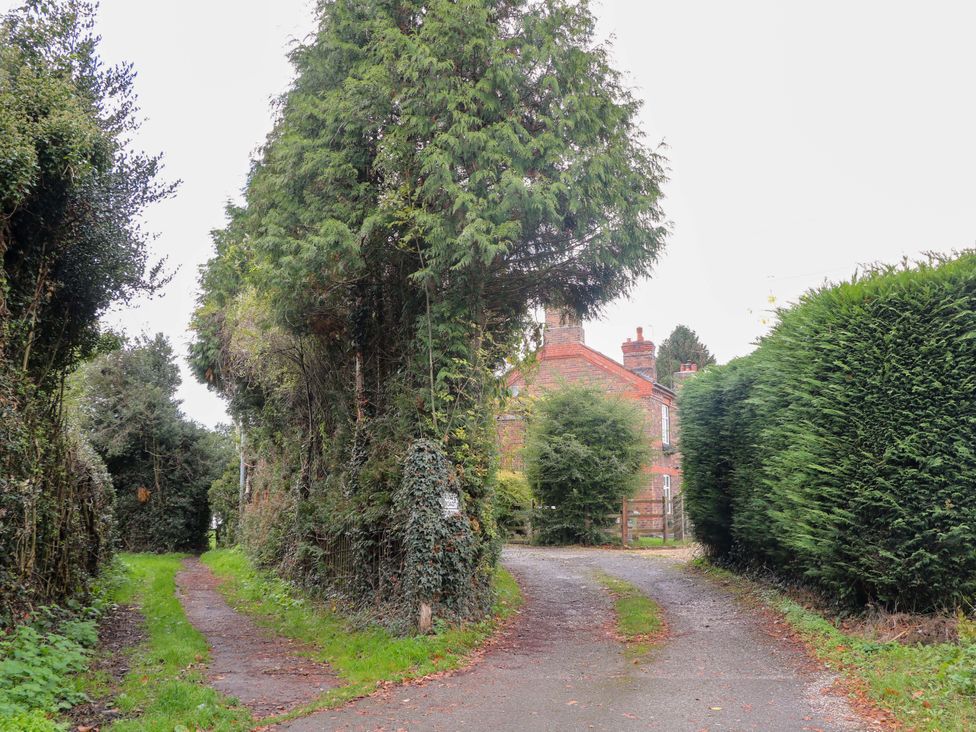 A view of a house surrounded by trees and hedges at Shunter’s Nook Stafford