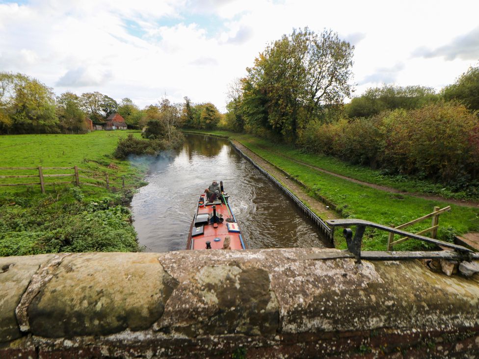 A canal with a narrowboat and trees at Shunter’s Nook in Stafford