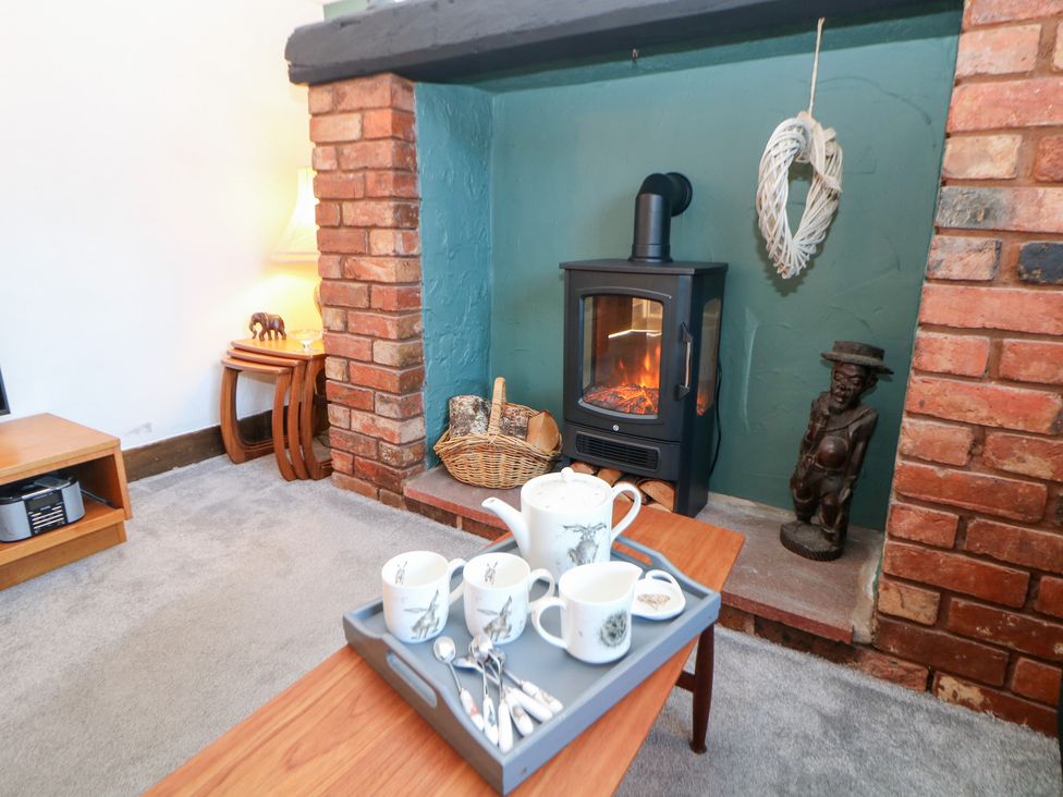 A living room with a fireplace and coffee table at Shunter’s Nook in Colwich