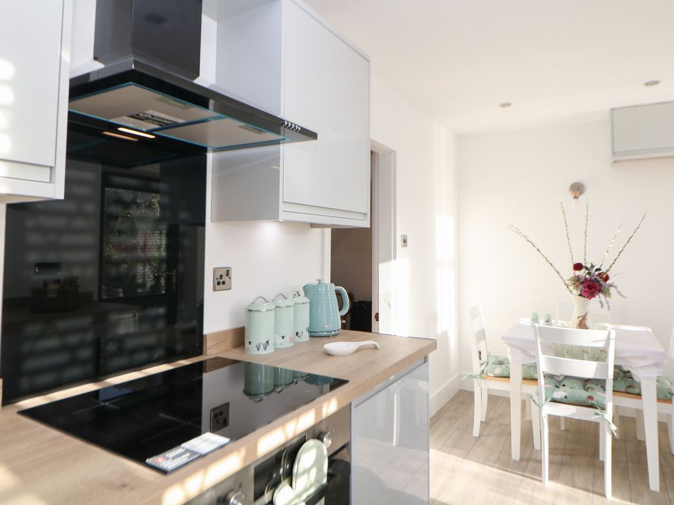 A kitchen with a stove and dining table at Shunter’s Nook in Colwich