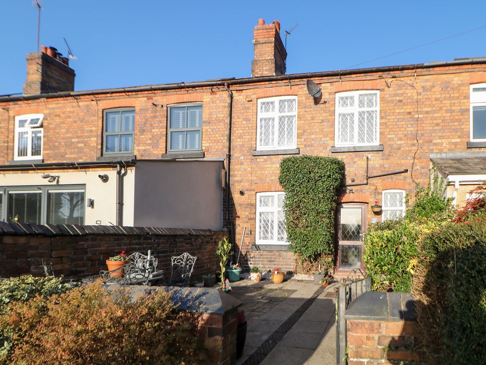 An outdoor garden with brick wall and plants at Shunter’s Nook in Colwich