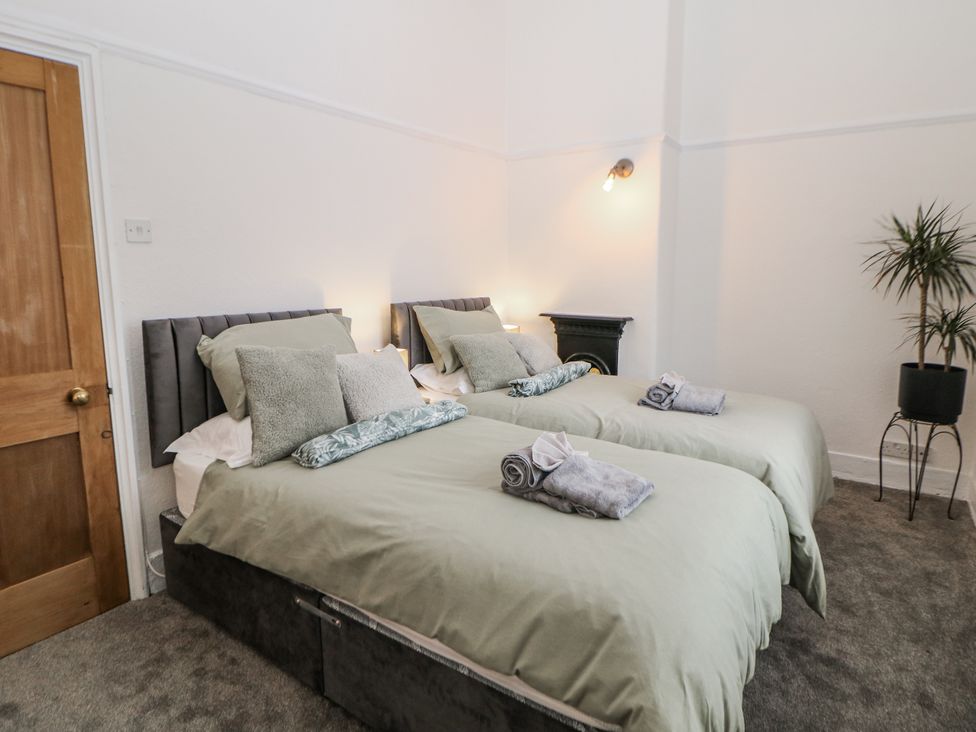 A bedroom with two beds and a plant at Shunter’s Nook in Colwich