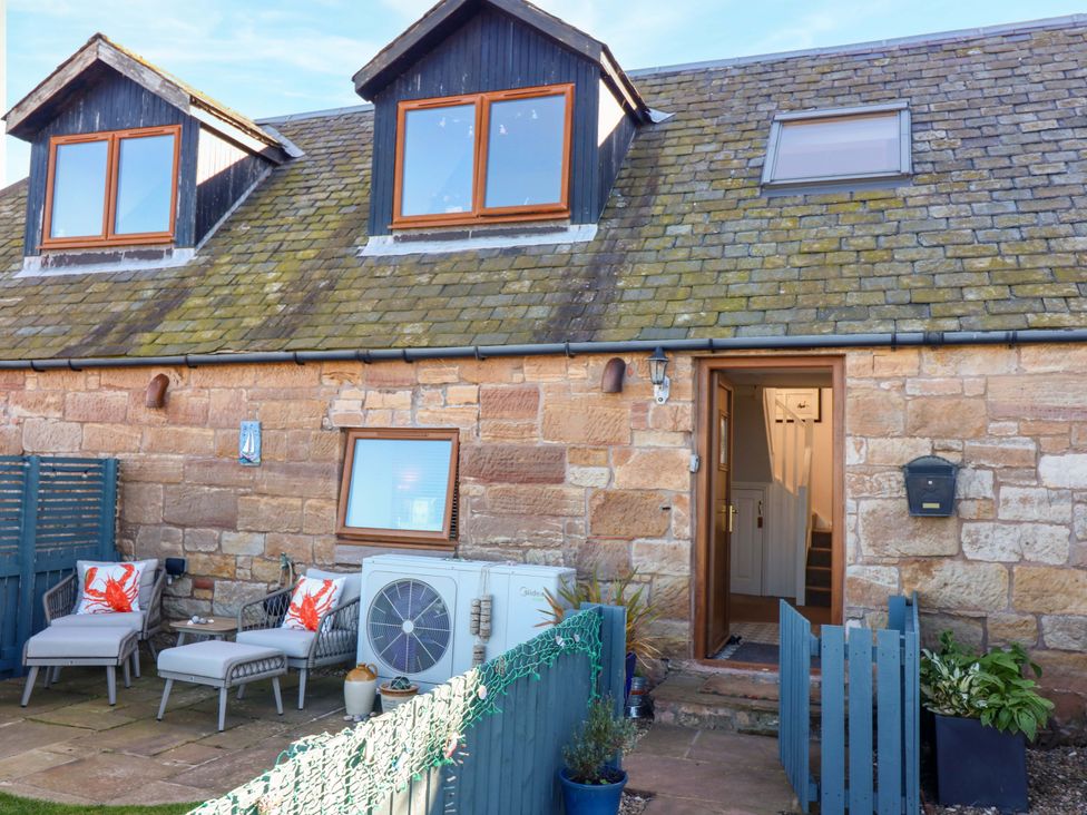 An outdoor area with chairs and plants at Bridle Cottage in Cockburnspath