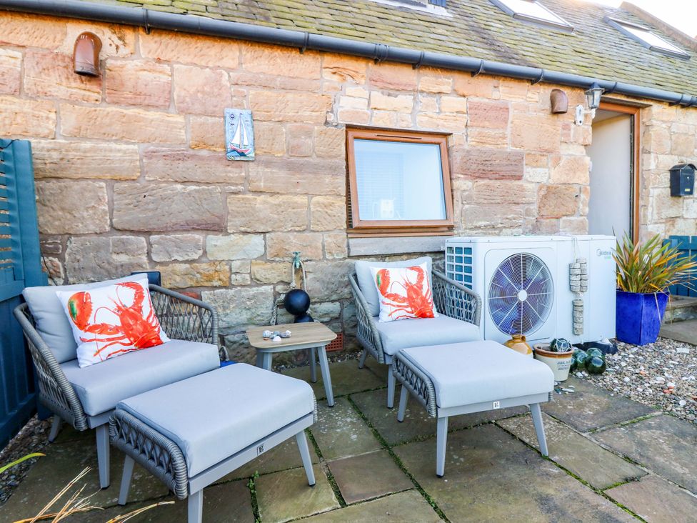 An outdoor seating area with chairs and a small table at Bridle Cottage in Cockburnspath