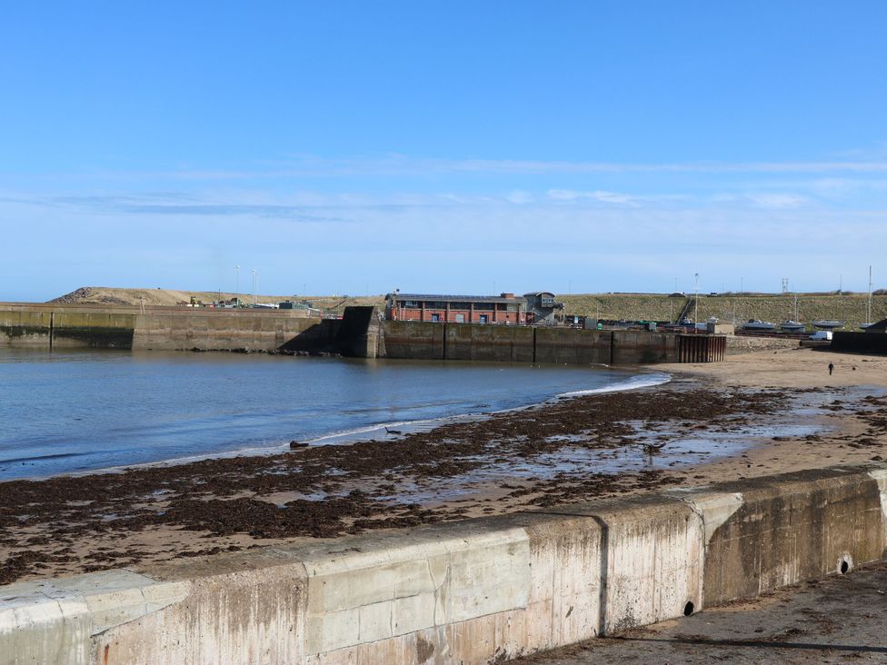 A view of a coastal area with water and a pier at Bridle Cottage Cockburnspath