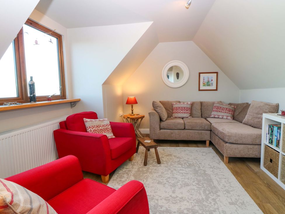 A living room with a sofa and armchair at Bridle Cottage in Cove