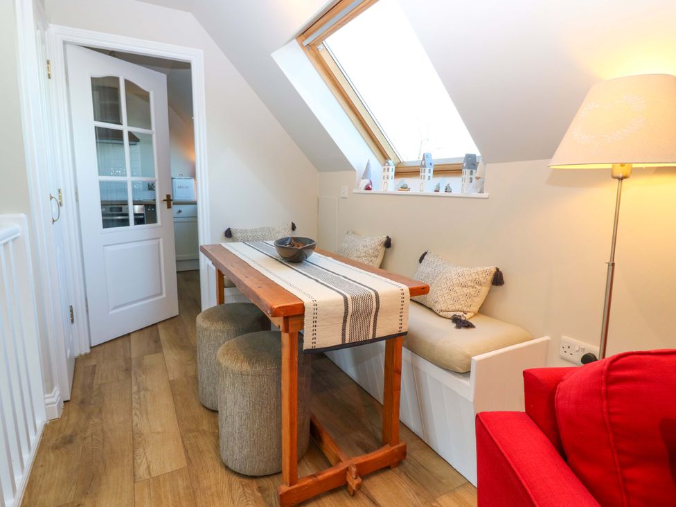 A dining room with a table and stools at Bridle Cottage in Cove