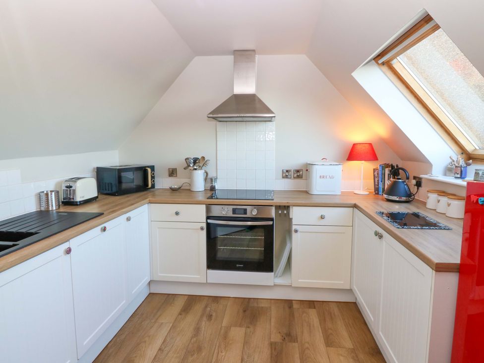 A kitchen with appliances and a window at Bridle Cottage in Cove