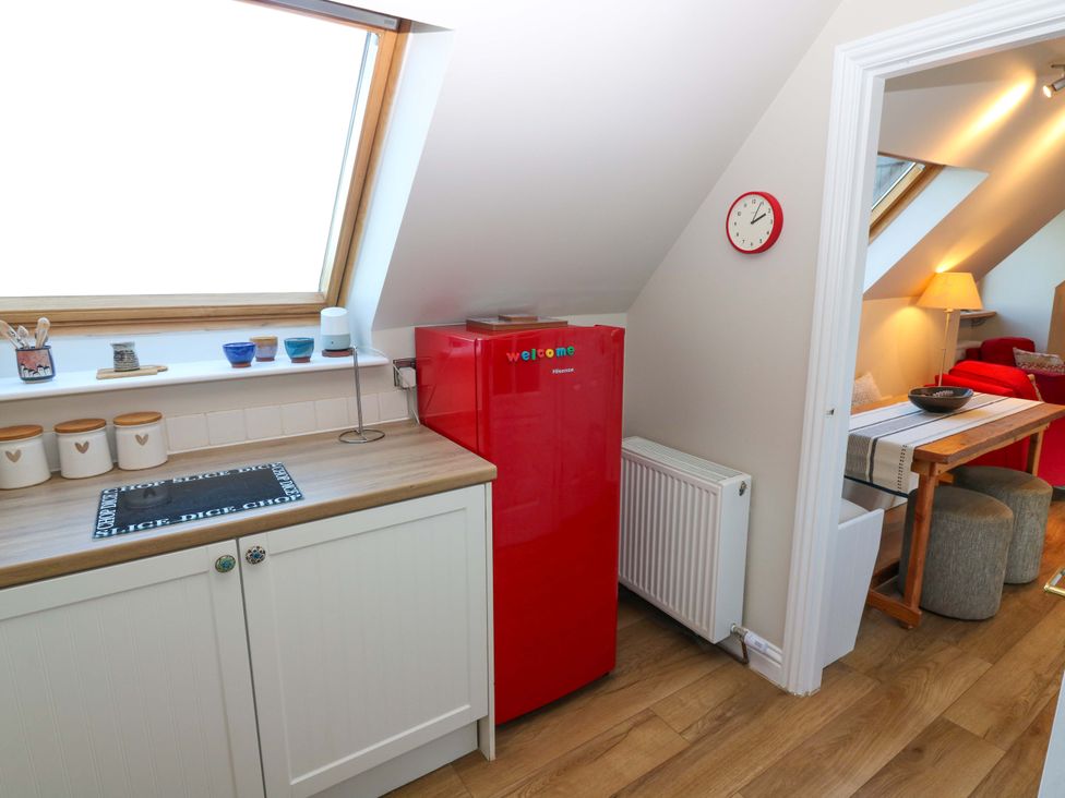 A kitchen with a red refrigerator and wooden countertops at Bridle Cottage in Cove
