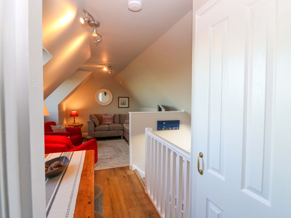 A living room with a sofa and chairs at Bridle Cottage in Cove