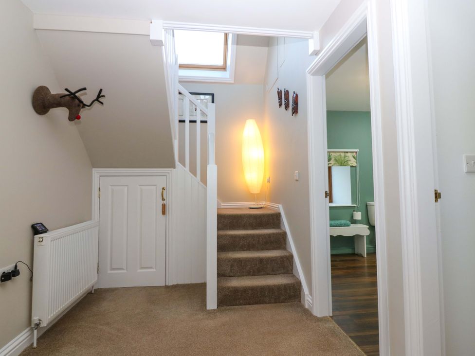 A hallway with a staircase and decorative elements at Bridle Cottage in Cove
