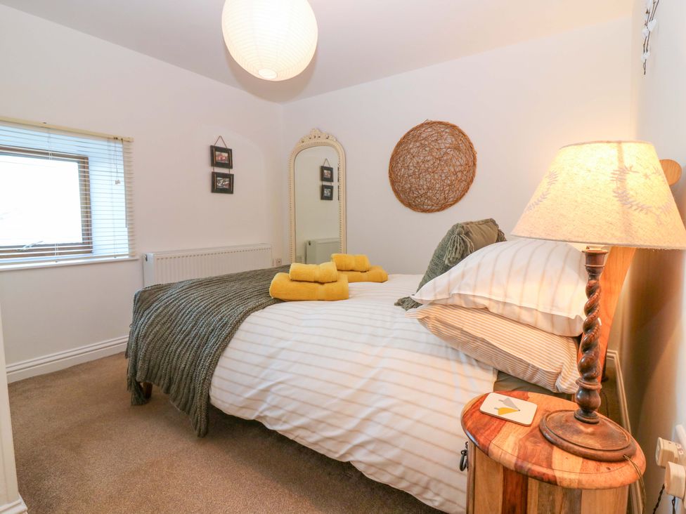 A bedroom with a bed and lamp at Bridle Cottage in Cove