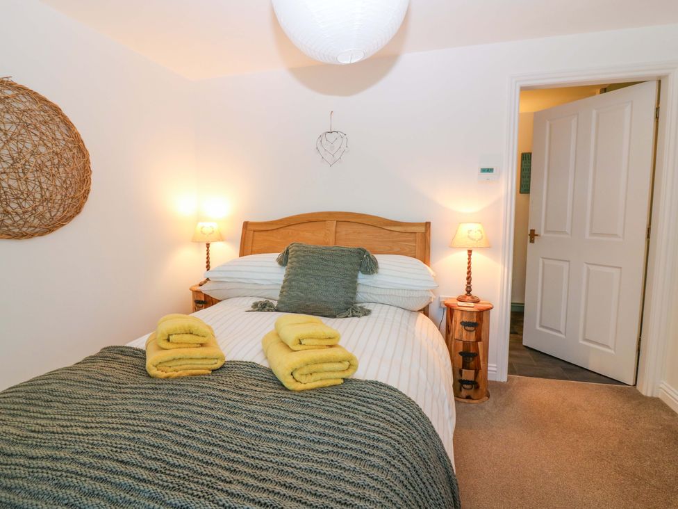 A bedroom with a bed and towels at Bridle Cottage in Cove