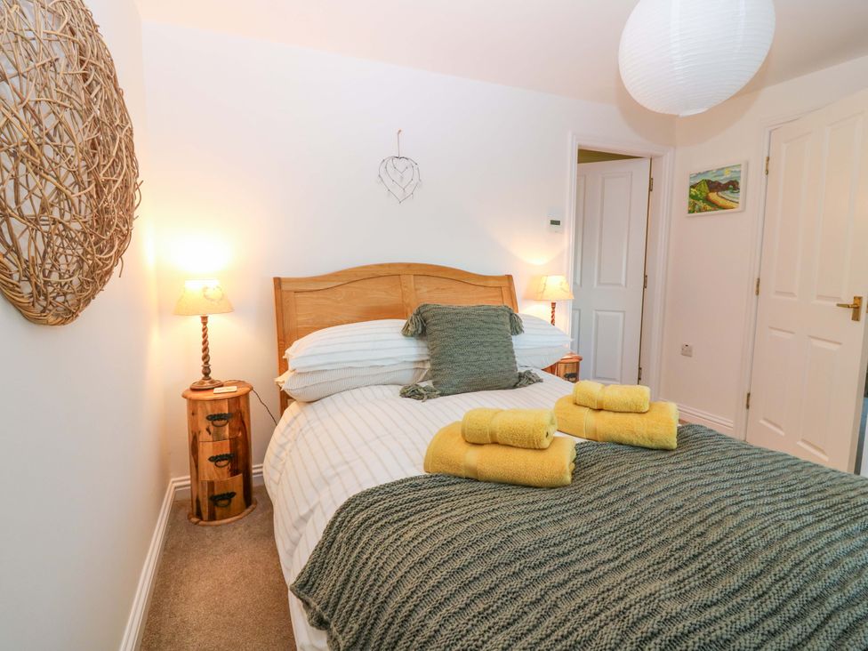 A bedroom with a bed and towels at Bridle Cottage in Cove